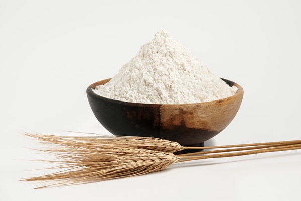 whole grain wheat flour isolated on white wheat flour filled in wooden bowl - Драники с пряностями