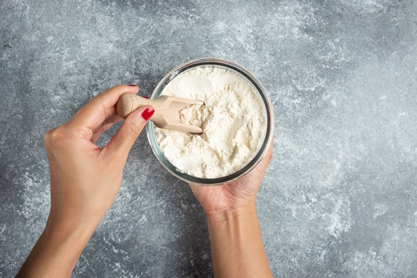 woman hand holding spoon inside of flour bowl - Деруны без яиц
