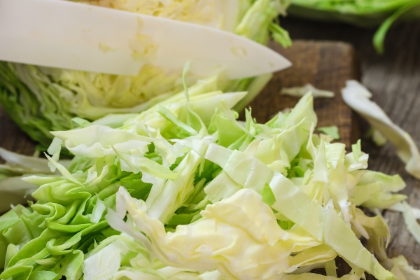 young cabbage on a wooden cutting board - Суп из овощей с патиссонами