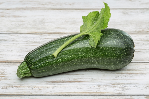young vegetable marrow squash with green leaf in studio - Драники кабачковые с луком и чесноком