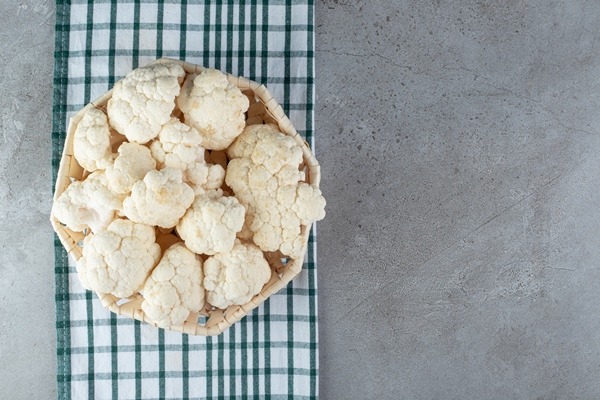 a wicker basket with uncooked cauliflower on a tablecloth high quality photo - Цветная капуста с грибами