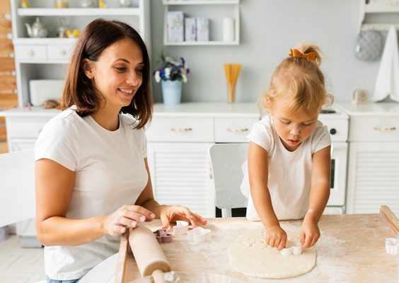 adorable little girl cutting dough for cookies - Как научить ребенка готовить?