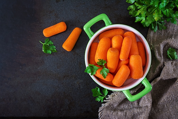 baby carrot sticks green bowl black surface healthy eating concept vegan food top view flat lay - Салат с рисом и тунцом на Благовещение