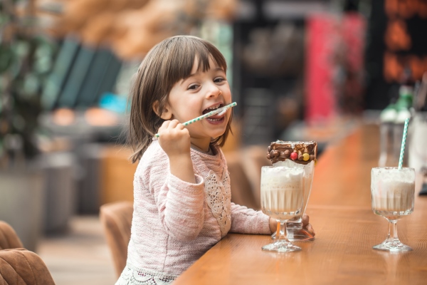 charming funny little girl drinks a milkshake - Банановый коктейль