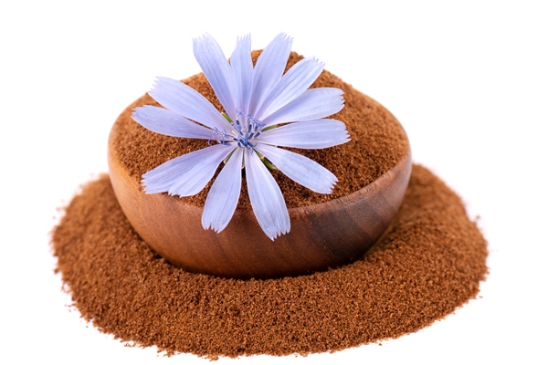 chicory powder and flower in wooden bowl isolated on white background cichorium intybus - Напиток из цикория с миндальным молоком