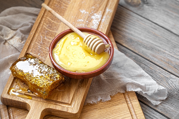 composition with natural honey and honey dipper on wooden background close up - Постный смузи из банана и кешью