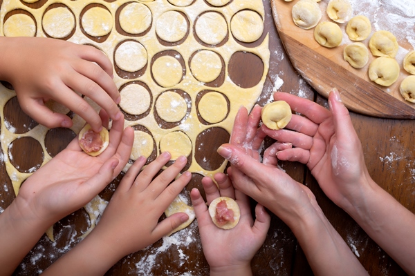 cooking ravioli of dough and meat with the whole family women s and children s hands homemade dumplings - Готовим пельмени вместе с детьми