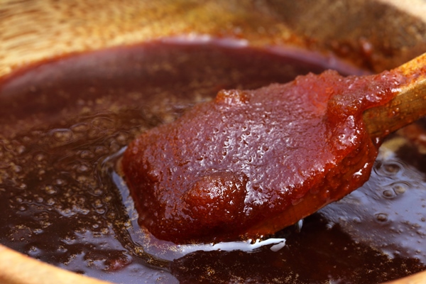 date molasses on wooden bowl with spoon - Сбитень на патоке