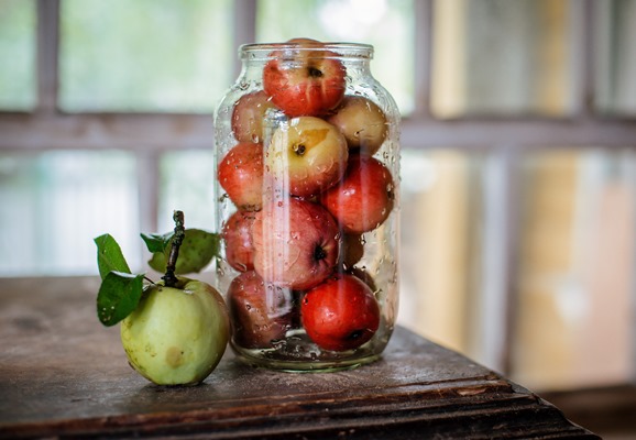 fresh harvest of ripe and healthy farm apples in a glass jar in a basket - Мочёные яблоки в банках