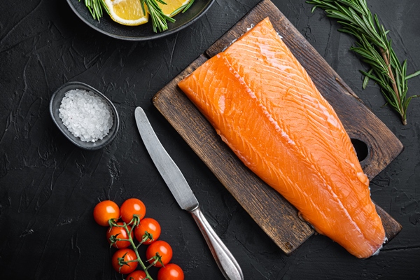 fresh whole salmon fillet on black background flat lay - Рыбный бульон из костей, голов и хвостов