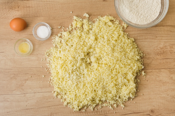 grated cheese salt egg flour for preparing italian gnocchi on wooden desk - Сырные палочки
