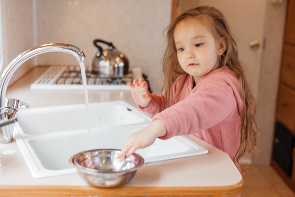 little girl washing dishes in the kitchen of a travel trailer - Готовим гречневую кашу вместе с детьми