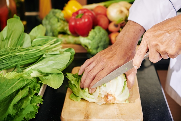 man cutting romaine lettuce - Зелёный салат со сметаной и яйцом