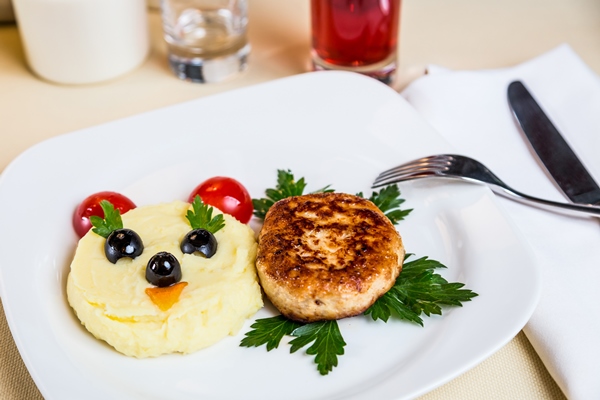 restaurant serving dish for child menu potato puree cutlet with face on white background -  Картофельное пюре