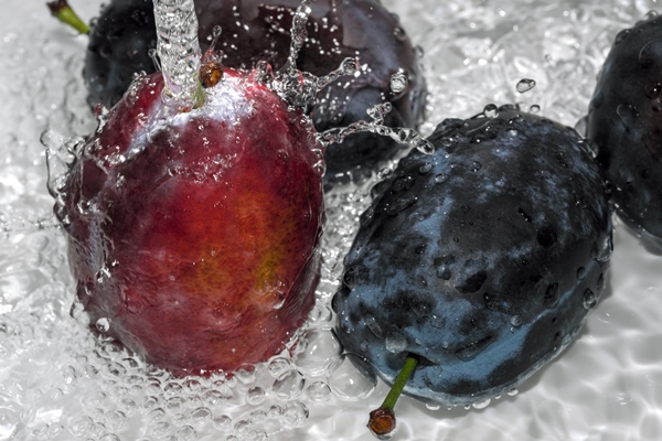 ripe sweet plums are washed under a stream of clean water close up macro photography - Сливовое варенье с косточками