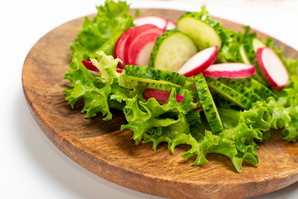 spring homemade radish salad with fresh cucumber and greens on wooden plate simple green rustic salat with sliced radishes cucumbers escarole and lettuce - Зелёный салат со сметаной и яйцом