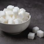 white sugar cubes in bowl on table - Кисель из клюквы