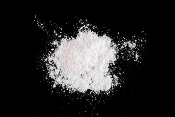 white wheat flour scattered on black table - Кисель из клюквы