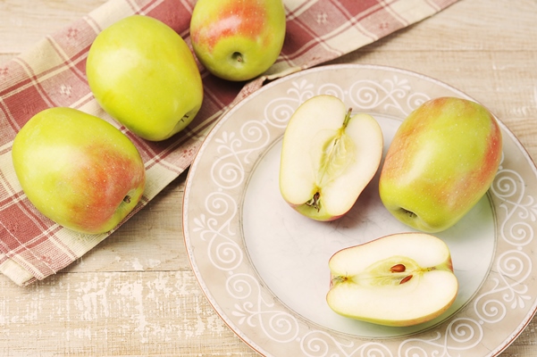 whole and cut apples on a plate - Замороженные яблоки на зиму