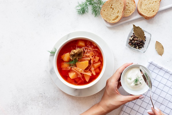 woman eating red borscht with vegetables - Борщ украинский с мясом