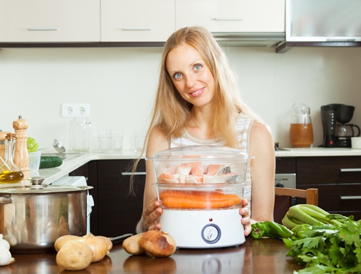 woman using electric steamer at home kitchen - Лосось на пару с овощным гарниром, постный стол