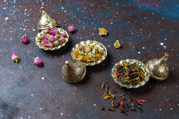 assortment of dry tea in golden vintage mini plates tea types background - Чай из лепестков роз