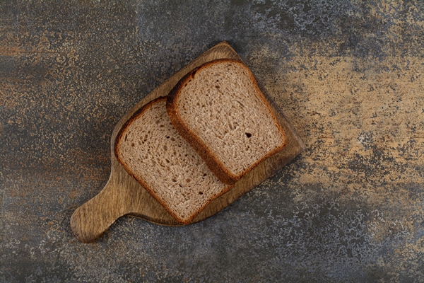 black toast bread on wooden board 1 - Бутерброды с авокадо чесноком и пряными травами