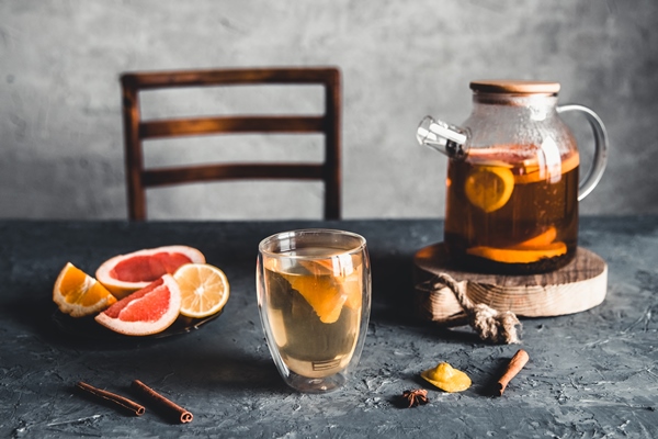 citrus tea in a transparent teapot on a gray concrete - Холодный чай с апельсинами