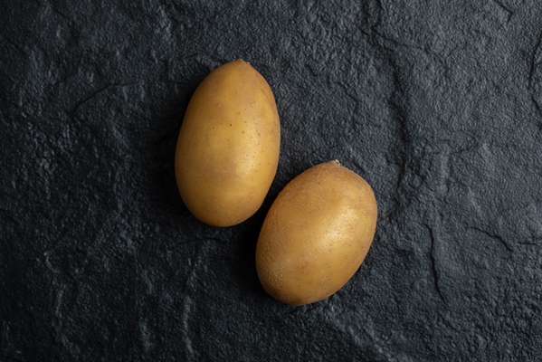 close up photo of two fresh potatoes on black background - Салат "Гранатовый браслет" постный
