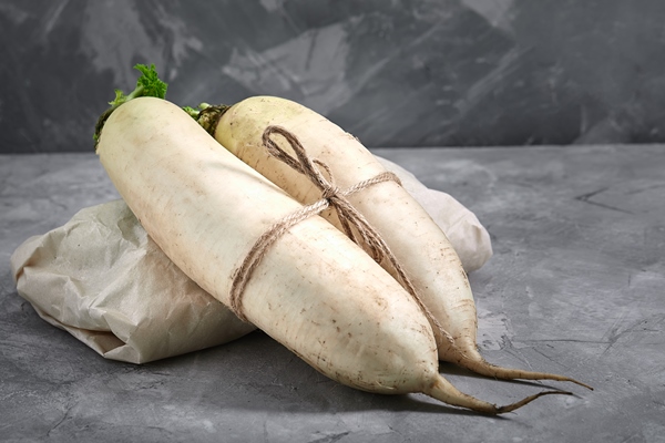 daikon radish on concrete background with space for text natural products gray background - Редька острая с мёдом