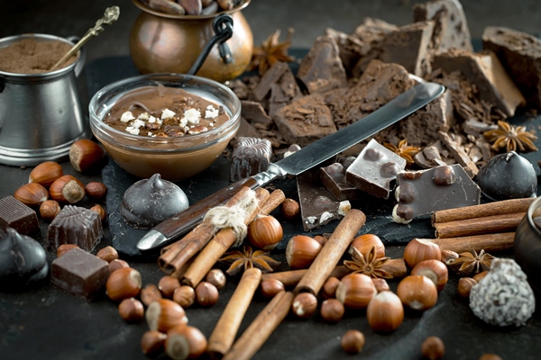 dark chocolate in a composition with cocoa beans and nuts on an old background - Постный ягодно-шоколадный десерт с хлопьями