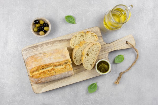 fresh italian ciabatta bread with herbs olive oil black and green olives basil leaves and pesto sauce on light gray concrete surface - Салат с перцем и хлебом