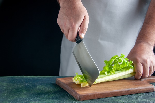 front view male cook cutting celery on dark wall health diet meal color photo food - Бутерброды с фасолевым паштетом и сельдереем