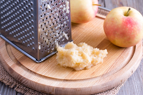 grated apple on plate on wooden table - Салат из моркови и яблок с сахаром и мёдом