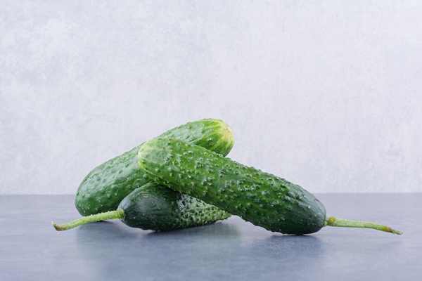 green cucumbers isolated on blue surface - Кукурузный салат с морепродуктами постный