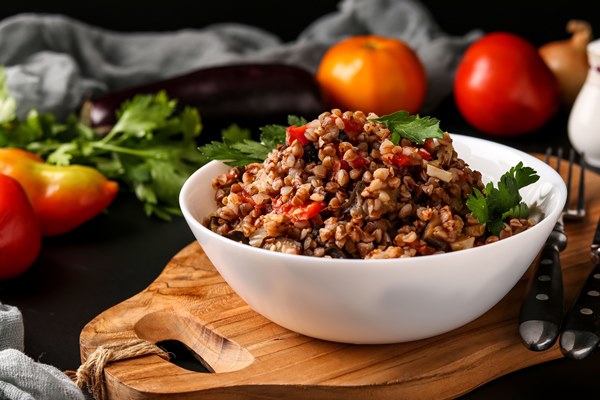 healthy buckwheat cooked with vegetables in a white bowl - Гречневая каша с баклажаном