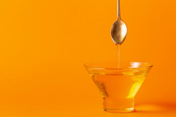 honey dripping off spoon in bowl with copy space - Редька острая с мёдом