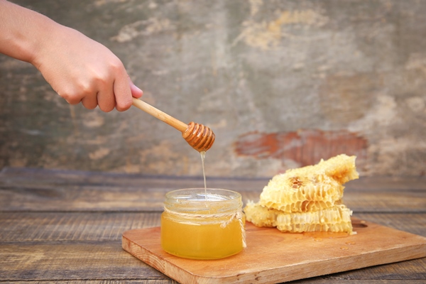 honey in a jar and honeycomb on an old wooden background - Салат из моркови и яблок с сахаром и мёдом