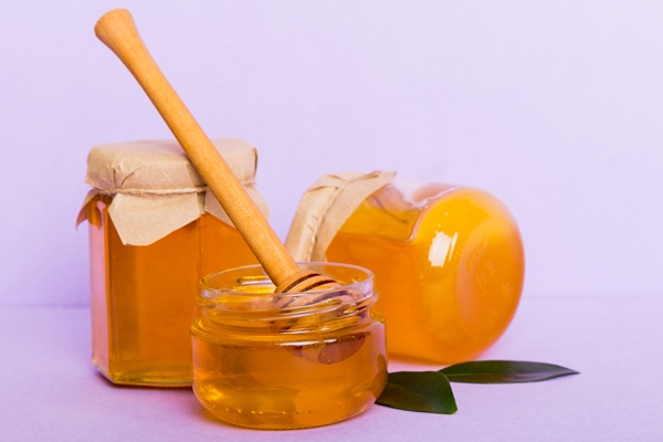 honey in jar with leaves and honey dipper on colored background top view with copy - Постный кекс с черносливом