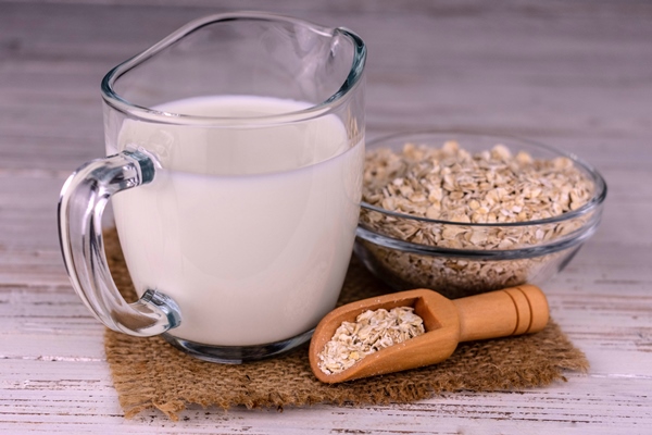 lactosefree oat milk in a glass decanter on a white background - Постная лазанья с чечевицей