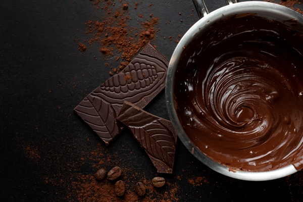 melted chocolate in pot with chocolate pieces around on dark surface - Постный ягодно-шоколадный десерт с хлопьями