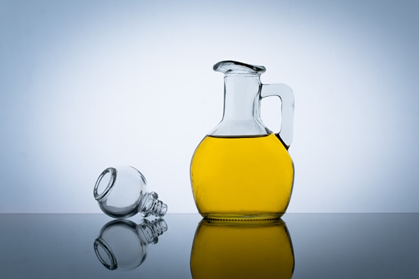 olive oil bottle vegetable salad flavoring gray background yellow cooking oil in a glass jar - Сушки к чаю