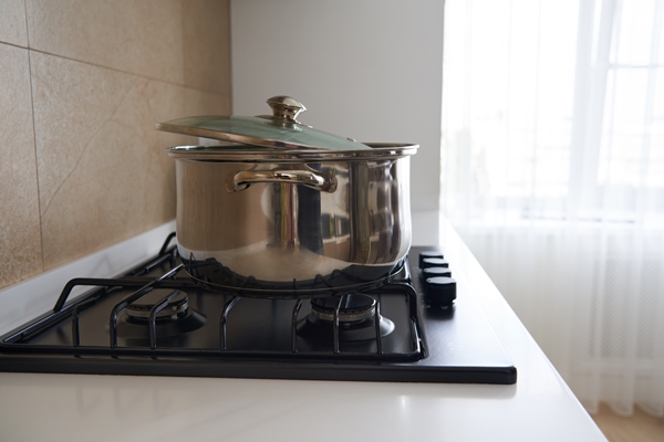 pan on the gas stove in kitchen interior stainless steel pot cooking utensils concept - Перловая каша с постным маслом