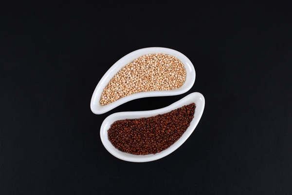 red and white quinoa seeds in white bowls on black background - Тыква, запечённая с киноа, постный стол