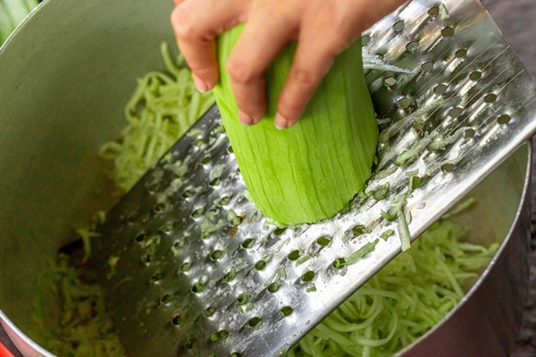 rubbing zucchini on a metal grater - Постные оладьи из кабачков