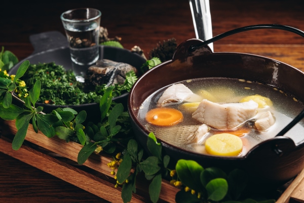 russian traditional fish soup in a bowl ukha served with ember and vodka on wooden board fish broth traditional cuisine in russia - Заливное из морепродуктов