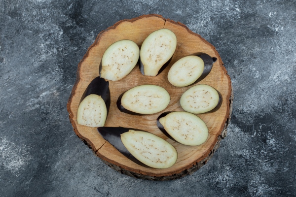 sliced raw eggplants on wooden board - Баклажанные рулетики с морковью