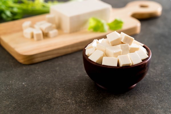 tofu on wooden board - Салат с грушей, орехами, шпинатом и тофу