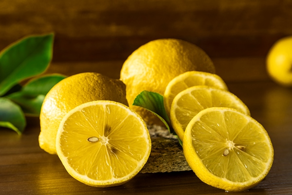 top view of lemon and green leaves on wooden - Морковный суп с зелёным соусом