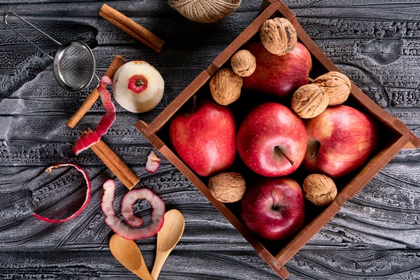 top view red apples in crate with cinnamon and walnuts on gray wooden horizontal - Салат из капусты с грецкими орехами